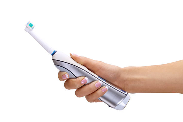 Hand holding electric toothbrush stock photo