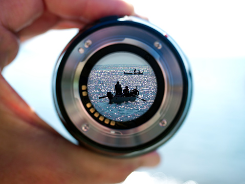 Hand holding filter lens camera, sunshine, seaside, landscape, boats