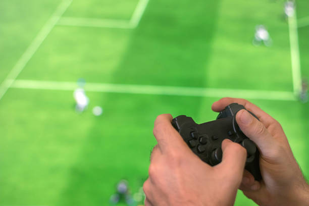 controller di gioco con mano che gioca a calcio. - joystick soccer foto e immagini stock