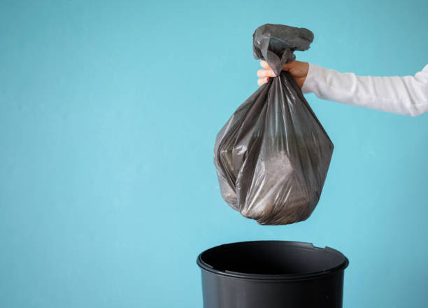 hand holding vuilnis in plastic zak - trash stockfoto's en -beelden