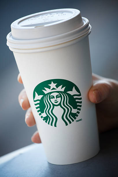Hand holding grande Starbucks take out coffee cup stock photo