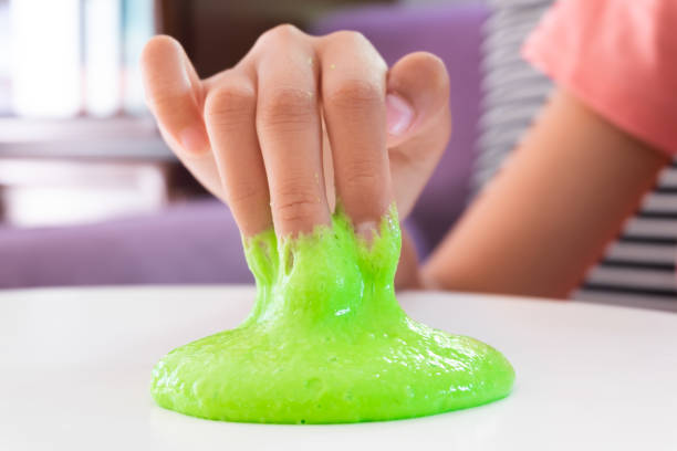 Hand Holding Homemade Toy Called Slime, Kids having fun and being creative by science experiment. stock photo