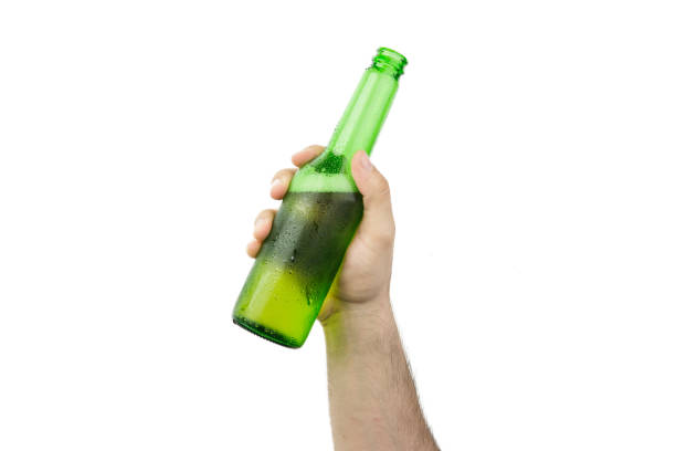 mano que sostiene la botella de cerveza verde húmedo frío de hielo aislado sobre fondo blanco - mano agarrando botella de cerveza y taza fotografías e imágenes de stock