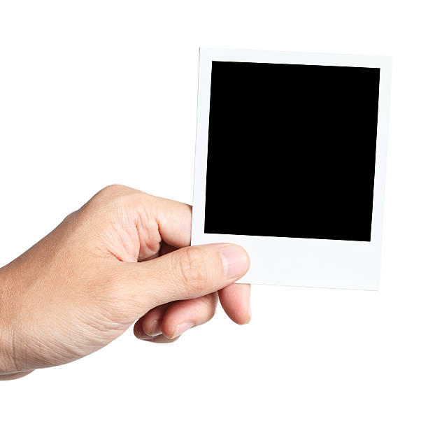 Hand Holding Instant Photo "A hand holding blank instant photo, isolated on white background. Clipping path included." holding photos stock pictures, royalty-free photos & images