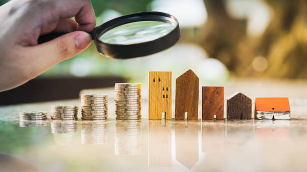 Hand holding magnifying glass and looking at house model with row of coin money, house selection, real estate concept. Hand holding magnifying glass and looking at house model with row of coin money, house selection, real estate concept. market research stock pictures, royalty-free photos & images