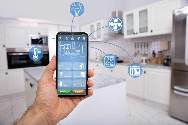Hand Holding Mobile With Smart Home Control Icon Feature Close-up Of Man's Hand Holding Mobile With Smart Home Control Icon Feature With Kitchen Background internet of things stock pictures, royalty-free photos & images