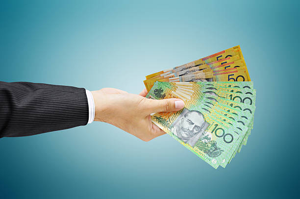 Hand holding money - Australian dollar (AUD) bills stock photo