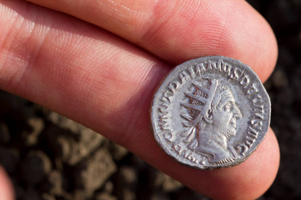 Hand holding Roman denarius (Roman silver coin) stock photo