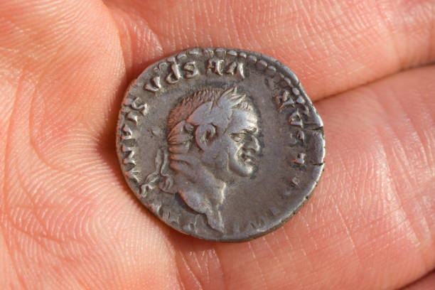 Hand holding Roman denarius (Roman silver coin) stock photo
