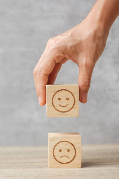 hand holding smile face block. Customer choose Emoticon for user reviews. Service rating, ranking, customer review, satisfaction, mood, mental health and feedback concept stock photo
