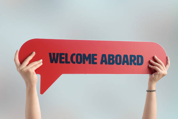 Hand holding the WELCOME ABOARD written speech bubble stock photo