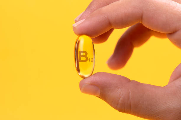 Hand Holding Vitamin B12 capsule stock photo