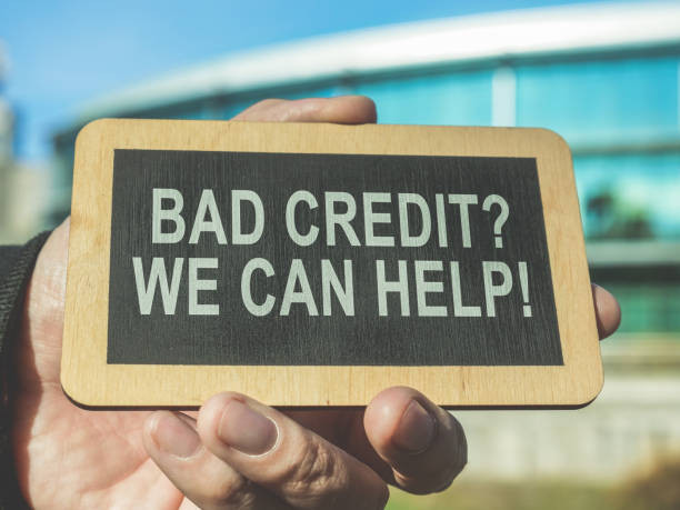 A hand holds a sign Bad credit, we can help. stock photo
