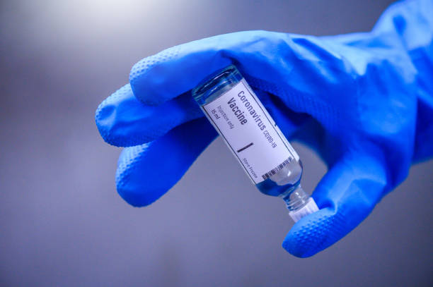 la main tient la bouteille en verre de vaccin de coronavirus covid-19 - covid 19 vaccin photos et images de collection