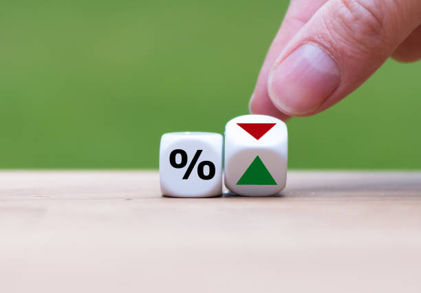 Hand is turning a dice and changes the direction of an arrow symbolizing that the interest rates are going down (or vice versa) Hand is turning a dice and changes the direction of an arrow symbolizing that the interest rates are going down (or vice versa) dice photos stock pictures, royalty-free photos & images