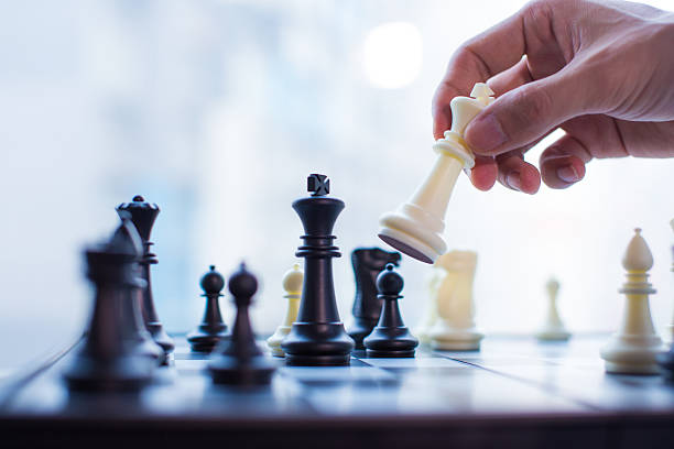 hand moving the king in chess game - schaken stockfoto's en -beelden