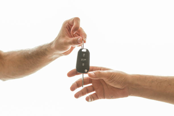 Hand of business man gives the car key with isolated on white stock photo