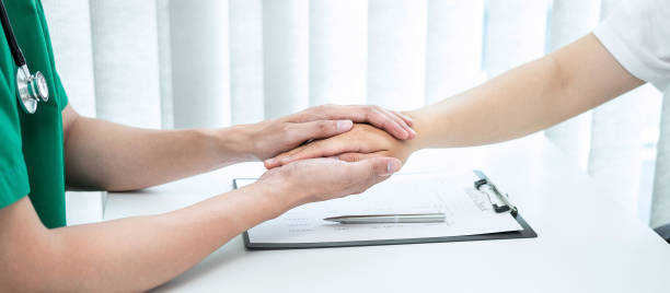 Hand of doctor touching patient reassuring for encouragement and empathy to support while medical examination on the hospital stock photo