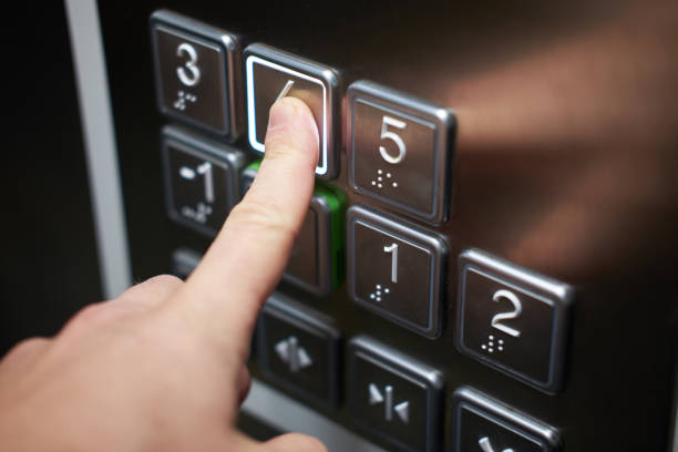 Hand of man pushing braille alphabet elevator button stock photo