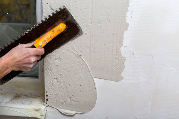 hand of man working plastering on wall stock photo
