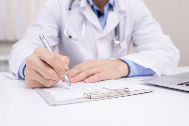Hand of professional clinician with pen over clipboard with medical document Hand of professional clinician with pen over clipboard with medical document going to make notes or prescription general practitioner stock pictures, royalty-free photos & images