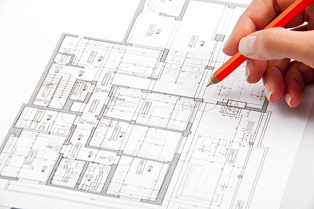 hand on architecture plans stock photo
