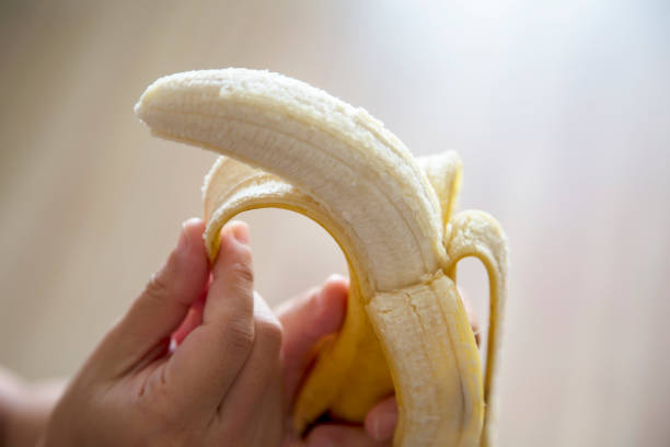 hand peeling banana stock photo