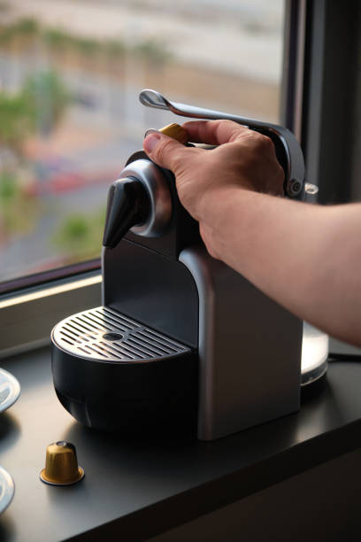 Hand preparing coffee in a coffee machine with capsules. stock photo