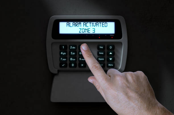 Hand Pressing Home Security System A male hand pressing a button of a home security control panel at night - 3D render burglar alarm stock pictures, royalty-free photos & images