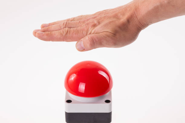 Hand pushing a red buzzer stock photo