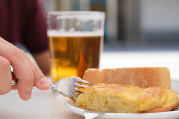 Hand taking a piece of Spanish omelette with a fork. stock photo
