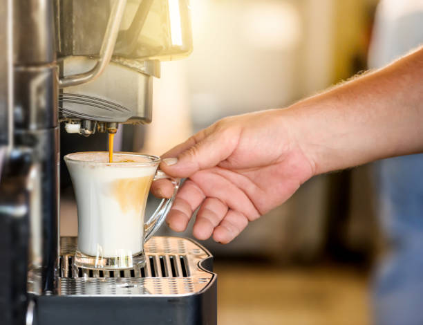 handeinnahme von kaffeetasse in der automatisierten kaffeemaschine. - kaffeeautomat stock-fotos und bilder