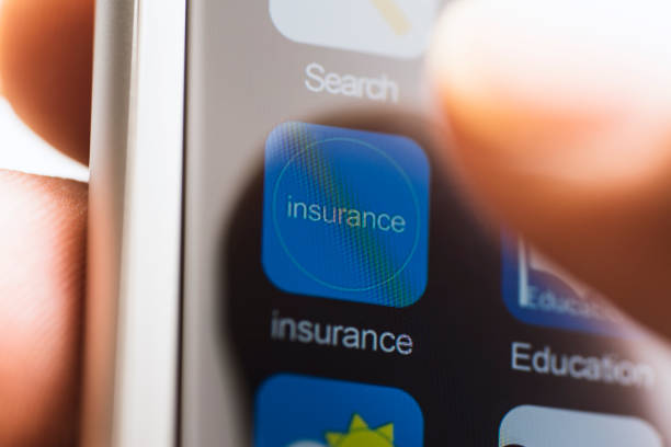 Hand touching insurance app icon on touchscreen stock photo