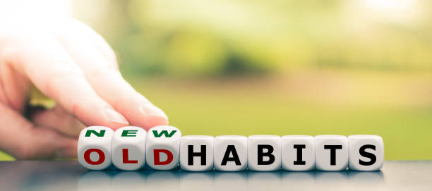 hand turns dice and changes the expression "old habits" to "new habits". - change habits imagens e fotografias de stock