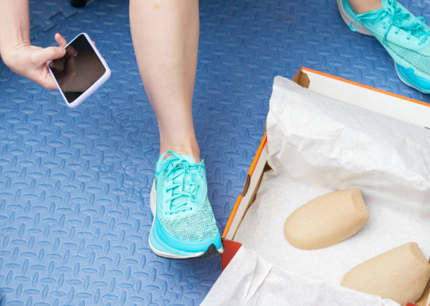 hand use smartphone to take picture on teal aqua running shoes in box package on floor stock photo