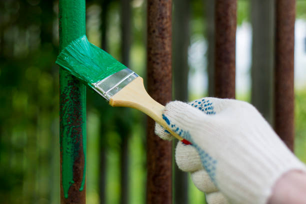 Hand wearing white gloves and painting with a paint brush. Hand wearing white gloves and painting with a paint brush. rusty fence stock pictures, royalty-free photos & images