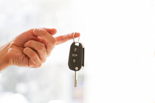 Hand with a car key. Isolated on white background stock photo