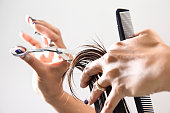 istock Hand with a comb cutting hair of woman 518564667
