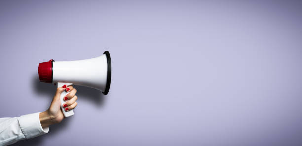 hand with a megaphone in front of an empty background hand with a megaphone in front of an empty background wind instrument stock pictures, royalty-free photos & images