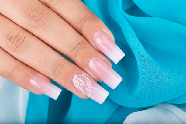 Hand with long artificial manicured nails with ombre gradient design Hand with long artificial manicured nails with ombre gradient design in pink and white colors artificial nail stock pictures, royalty-free photos & images