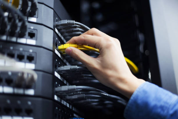 Hand with network cable in a technology data center stock photo