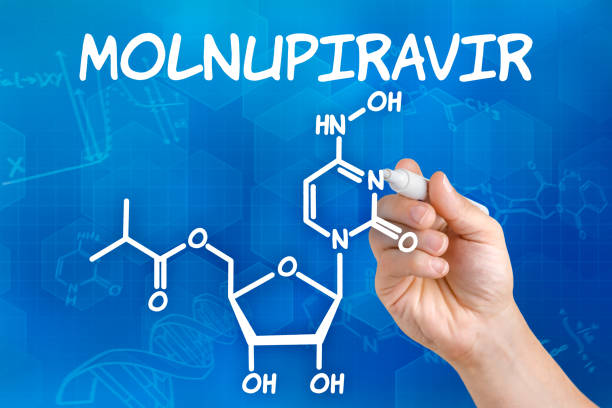 Hand with pen drawing the chemical formula of Molnupiravir stock photo
