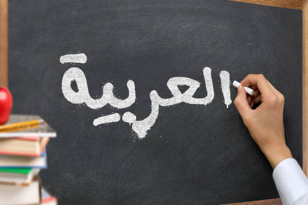 tulisan tangan di papan tulis dalam kursus kelas belajar bahasa arab dengan teks "arab" tertulis di atasnya. dengan beberapa buku dan konsep materi sekolah. - pelajaran arab potret stok, foto, & gambar bebas royalti