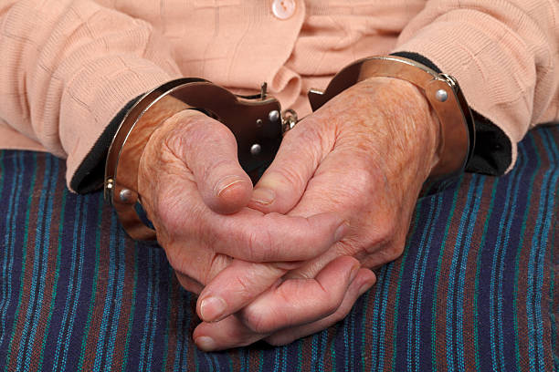 Handcuffed  elderly woman stock photo