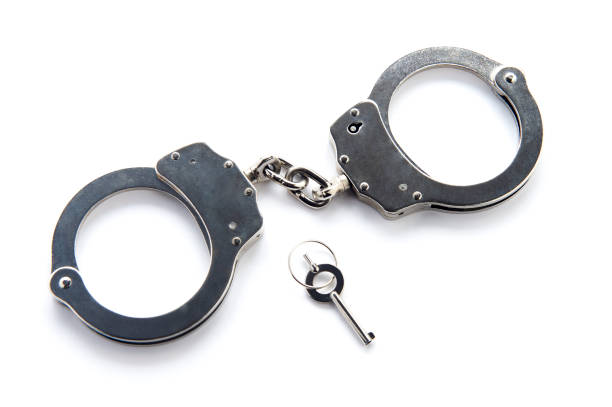 Handcuffs and key isolated on white background stock photo