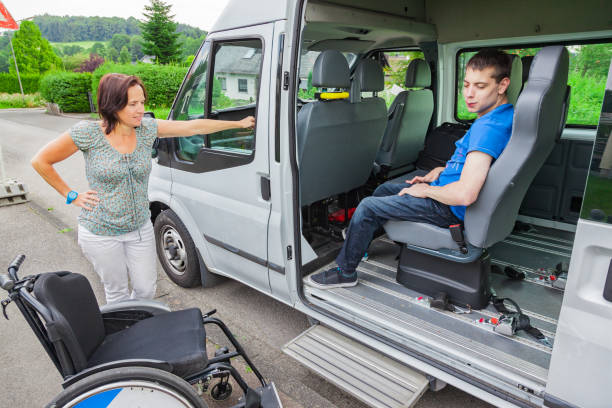 Handicapped boy is picked up by school bus stock photo