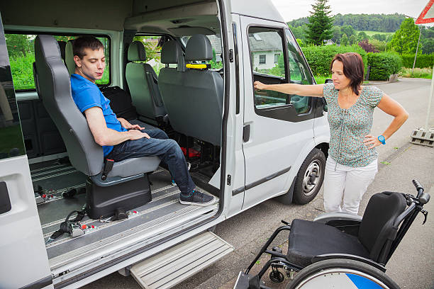 Handicapped boy is picked up by school bus stock photo