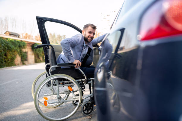 Handicapped man attempting to get in the car Handicapped man attempting to get in the car in the handicapped parking zone physical disability stock pictures, royalty-free photos & images