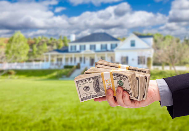 Handing Over Cash For House in Front of Home stock photo