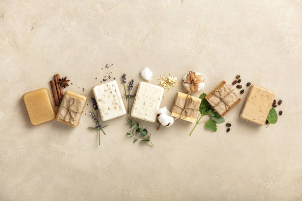 Handmade organic soap bars and ingredients on natural stone background, flat lay stock photo